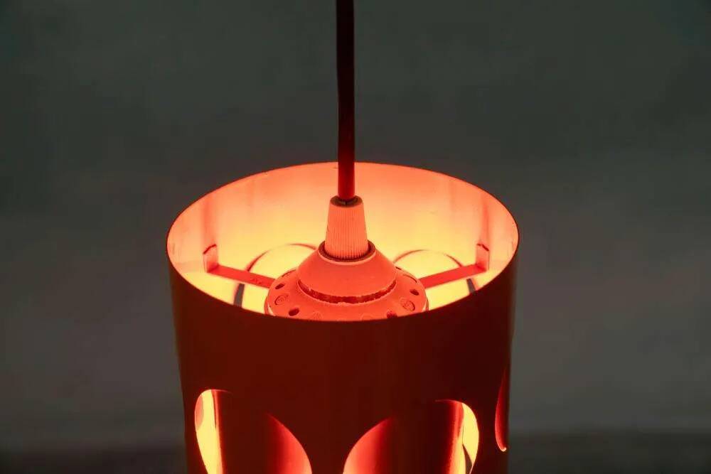 Vintage orange suspension light in a 1970s space age style.