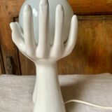 Ceramic table lamp depicting two hands holding a globe, 1980