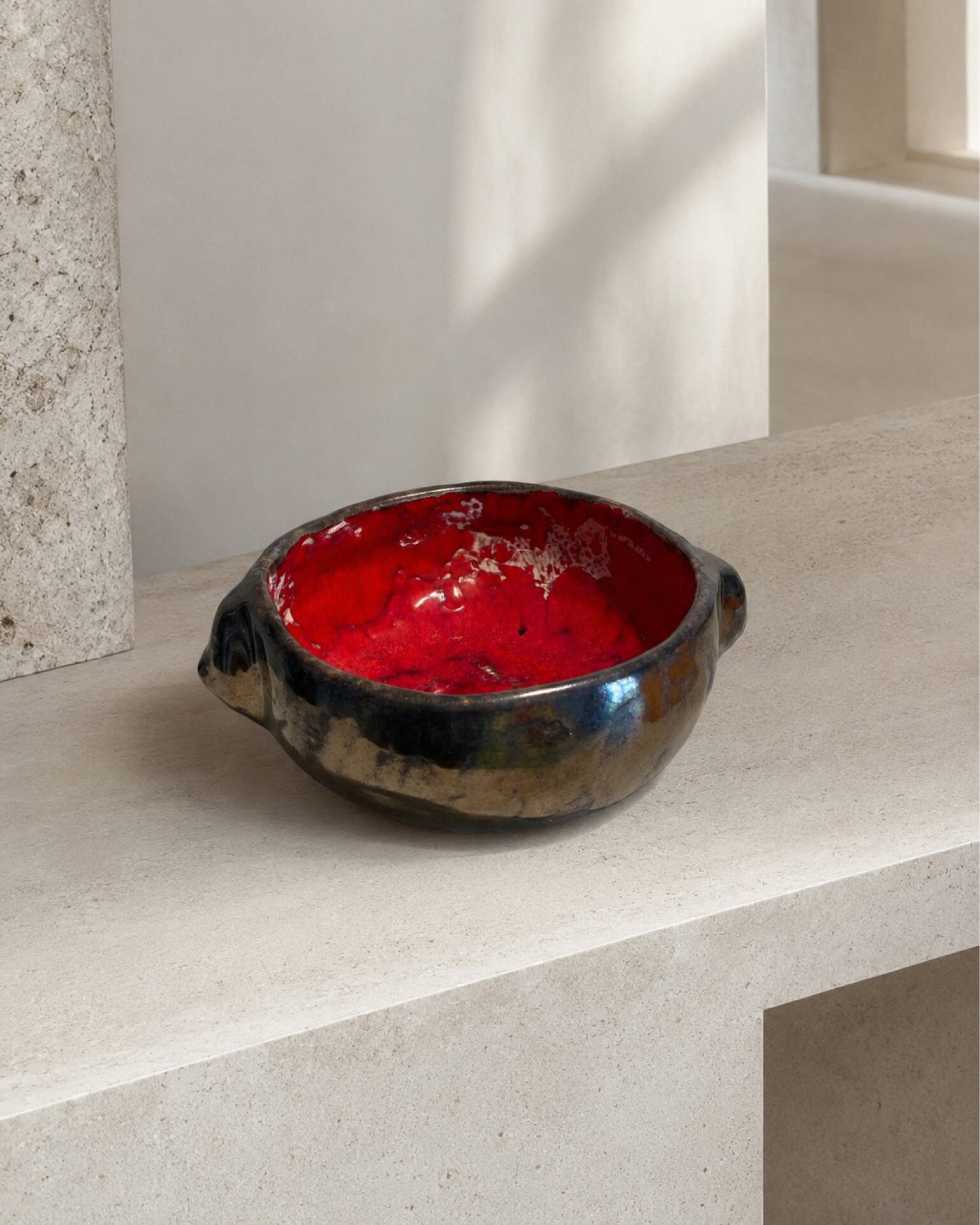 Deep red glazed and metallic ceramic catchall.