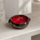 Deep red glazed and metallic ceramic catchall.