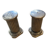 Antique salt and pepper shakers in the shape of a column.