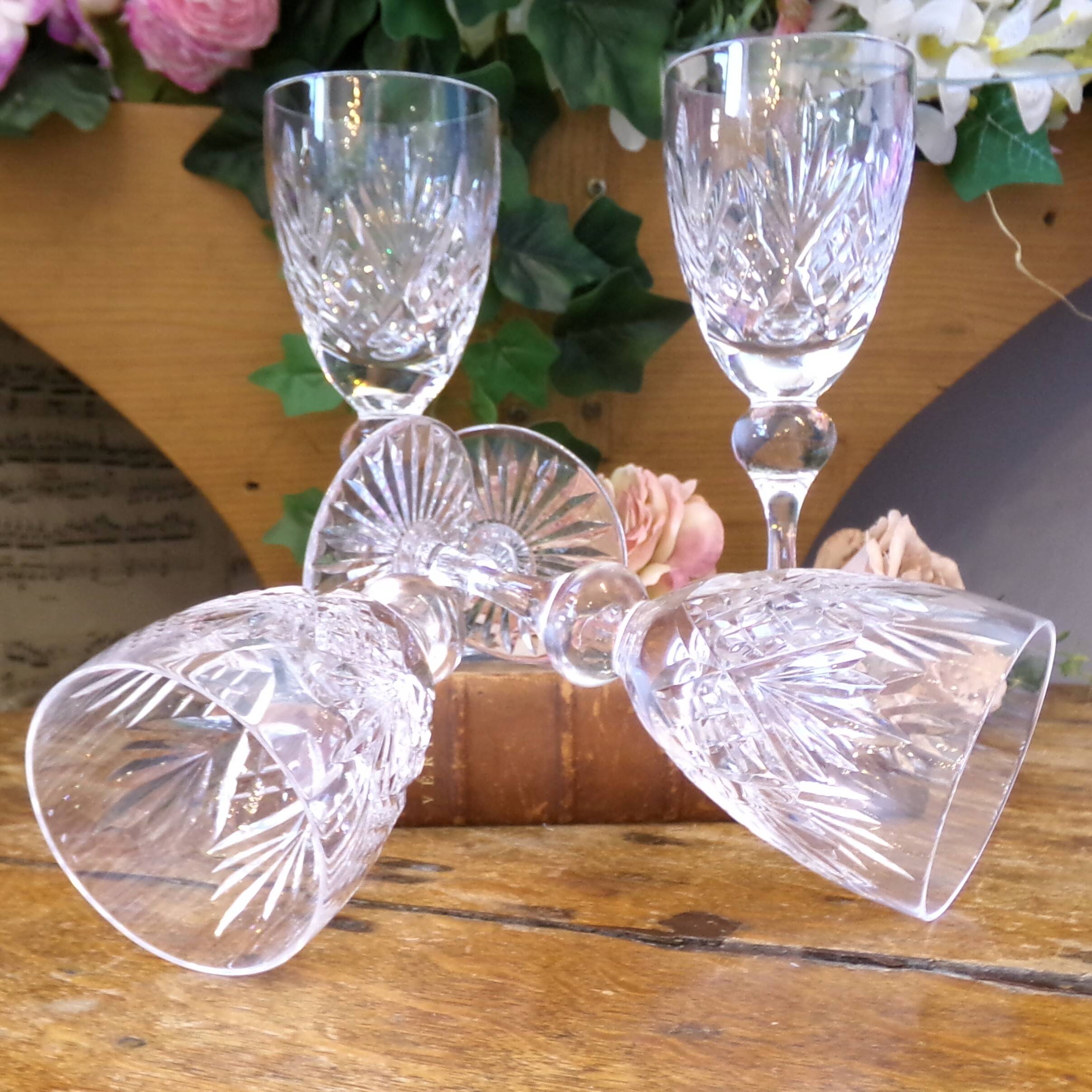 Cut crystal white wine glasses with a slender baluster-shaped stem.