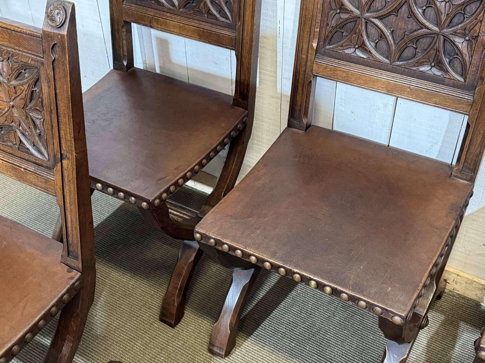 Suite de 6 chaises et 2 fauteuils en chêne et cuir à décor gothique