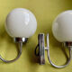 Pair of chrome metal wall lights with white glass globe.