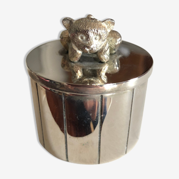 Silver box topped with a teddy bear