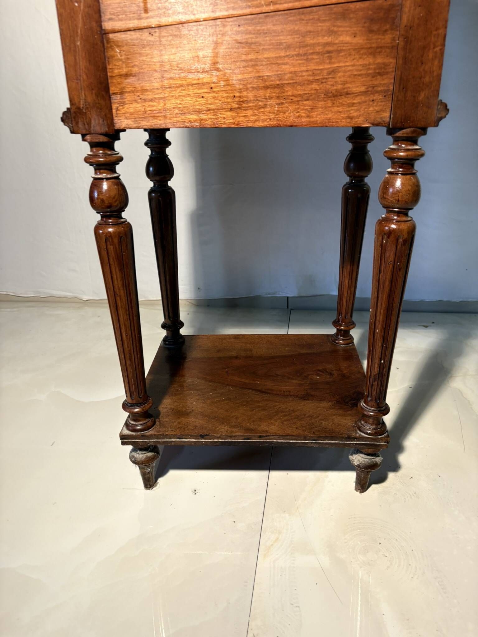 Antique wooden bedside table with turned legs.