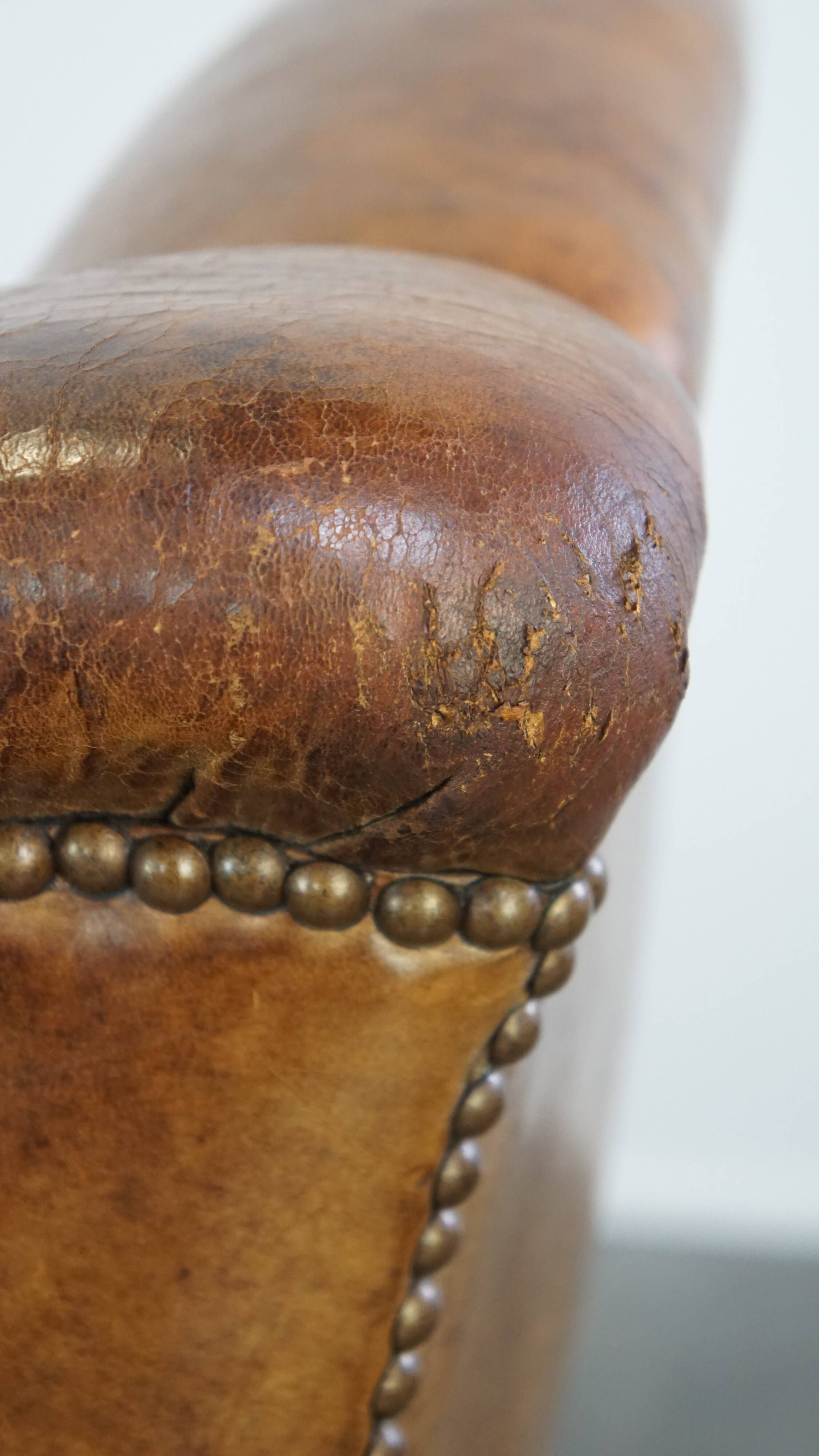 Fauteuil en cuir de mouton antique caractéristique avec de beaux détails et un design unique