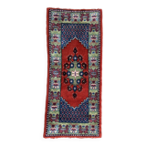 Vintage hand-knotted wool rug with polychrome decoration on a red, blue, green background 150 x 63 cm
