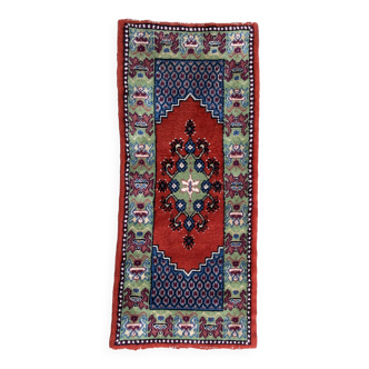 Vintage hand-knotted wool rug with polychrome decoration on a red, blue, green background 150 x 63 cm