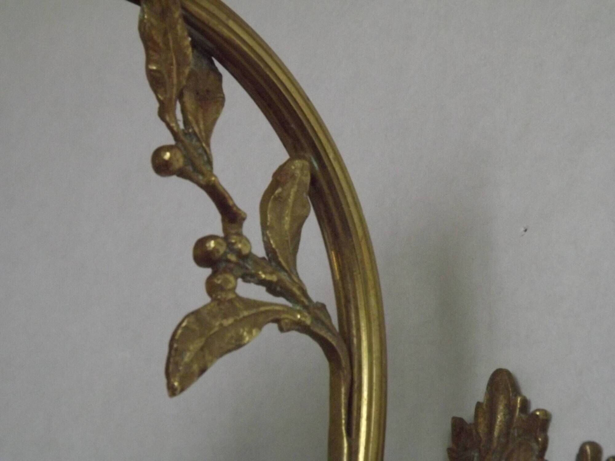 Simple wall sconce in French Art Nouveau bronze with a white glass shade featuring patterns.