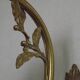 Simple wall sconce in French Art Nouveau bronze with a white glass shade featuring patterns.