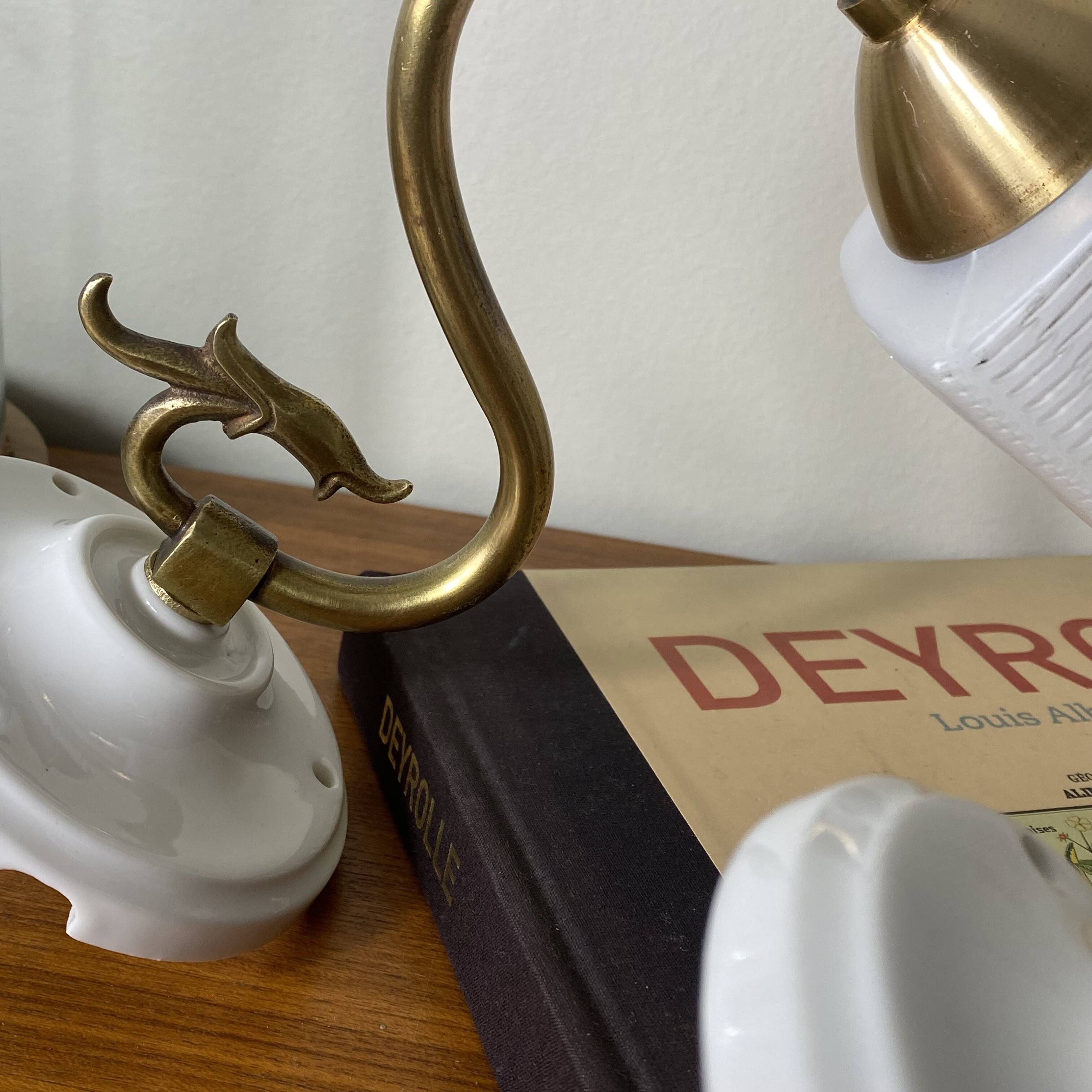 Pair of swan neck wall lights in brass, white glass and porcelain.