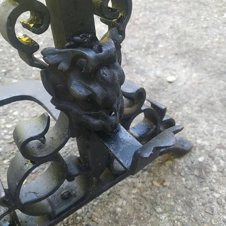pair of large 20th century metal andirons with mascaron decoration