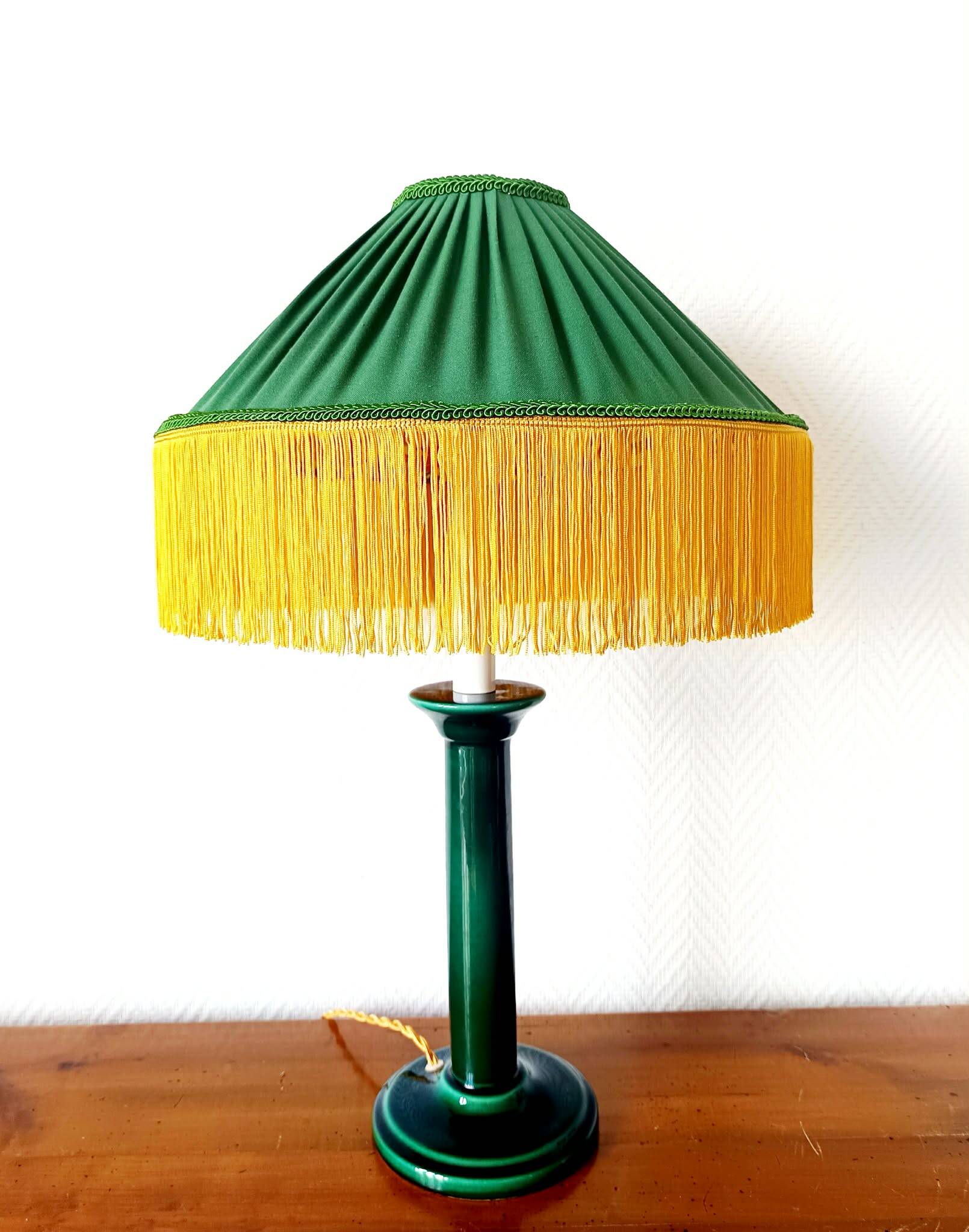 Green ceramic lamp with a vintage pleated fringe shade.
