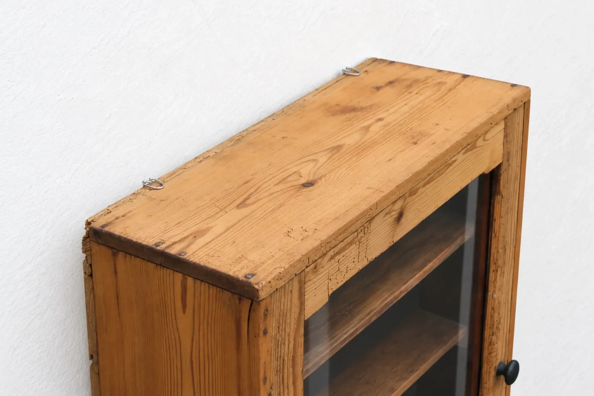 Antique wall display cabinet in natural wood and black – small glass-fronted collector's piece.