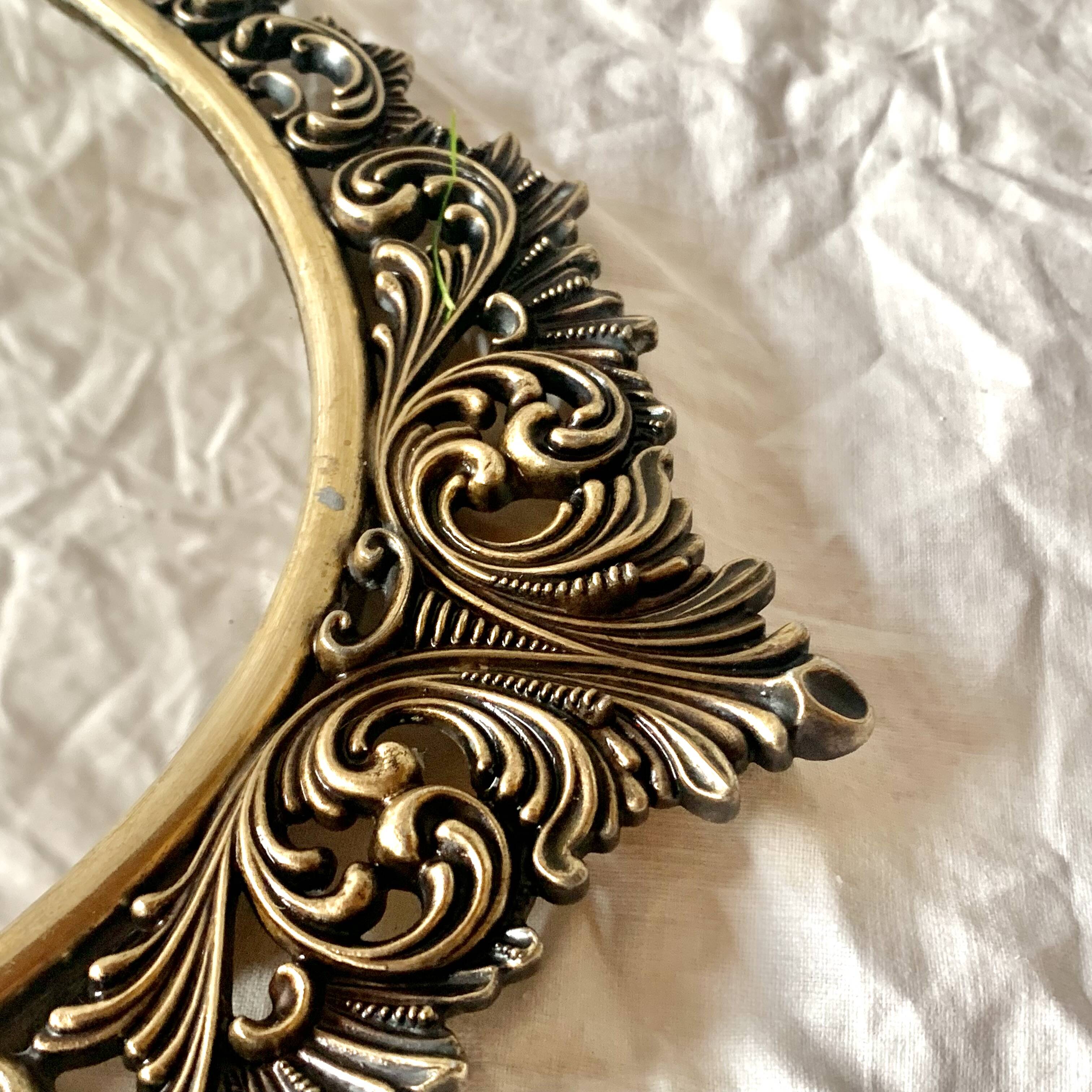 Old oval wall mirror in gilded brass