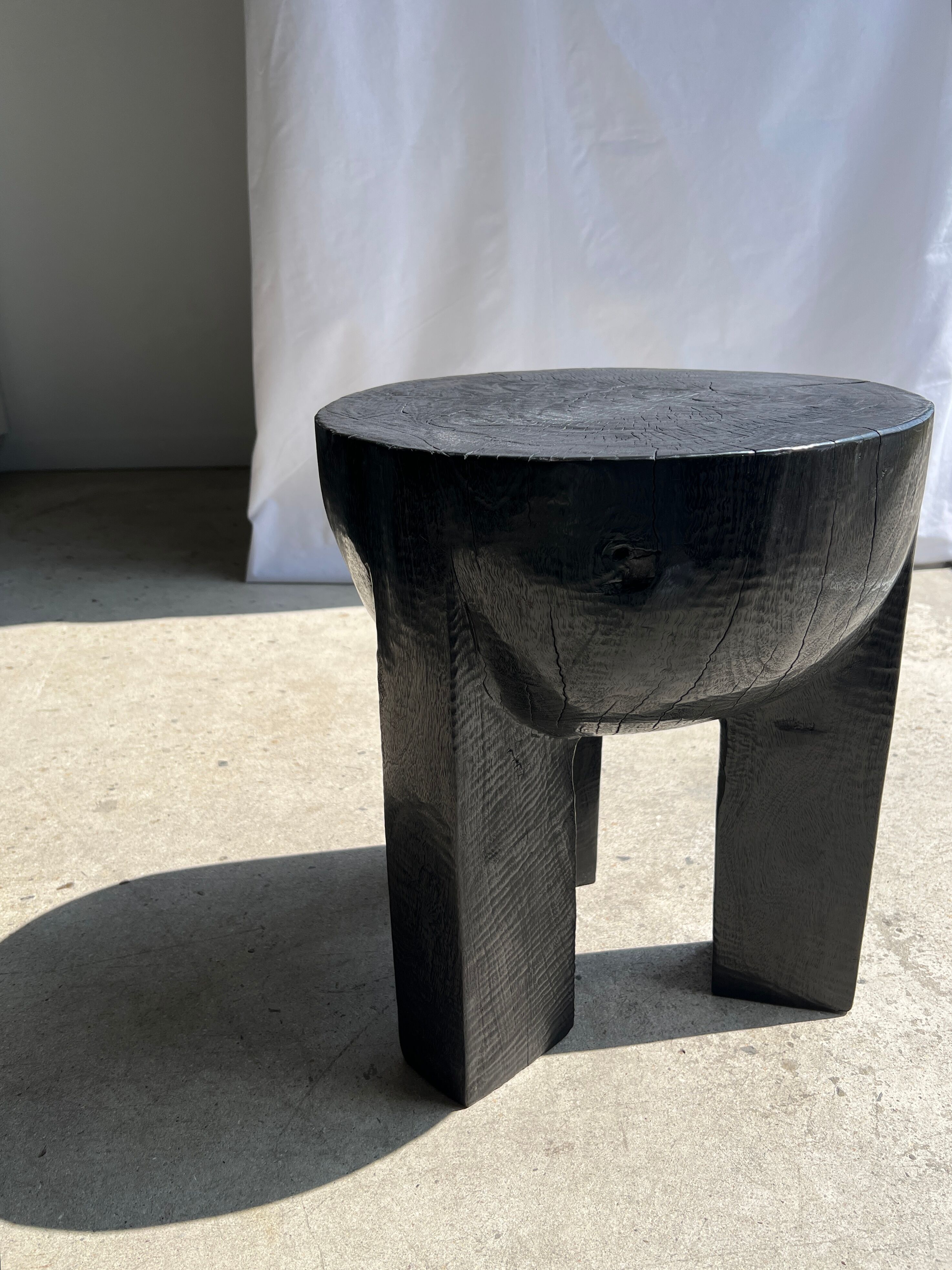 Black mango wood tripod side table with a semi-spherical top, height: 45 cm, diameter: 44 cm.