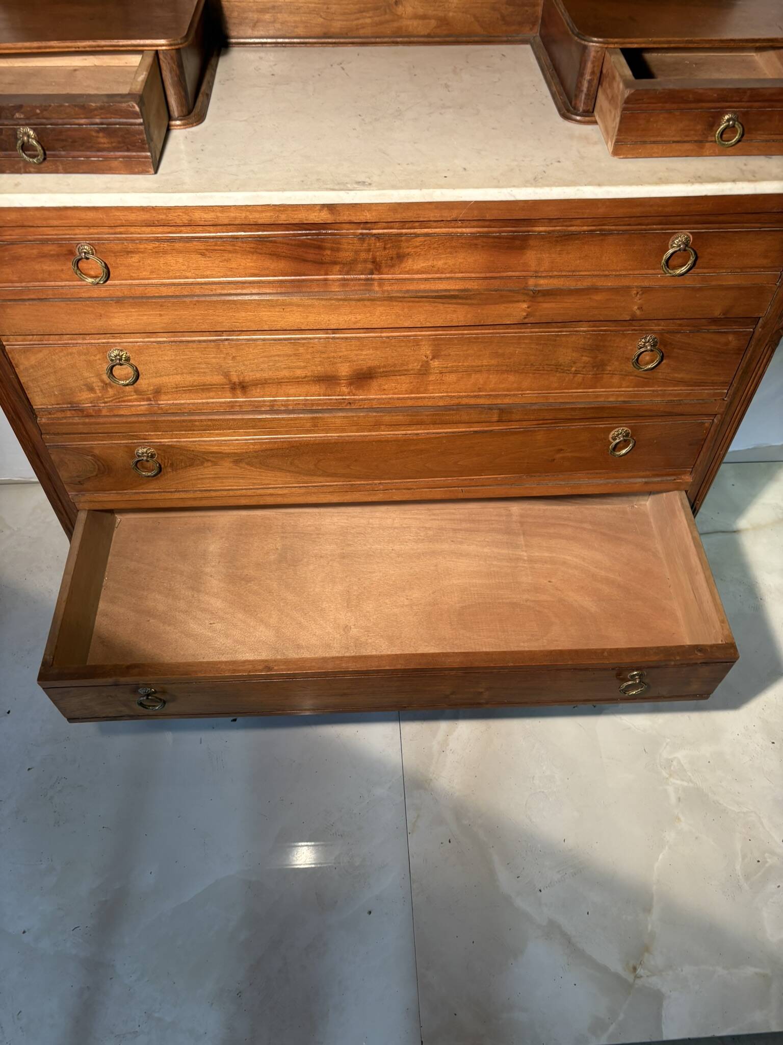 Antique carved wooden dressing table with marble and tilting oval mirror.