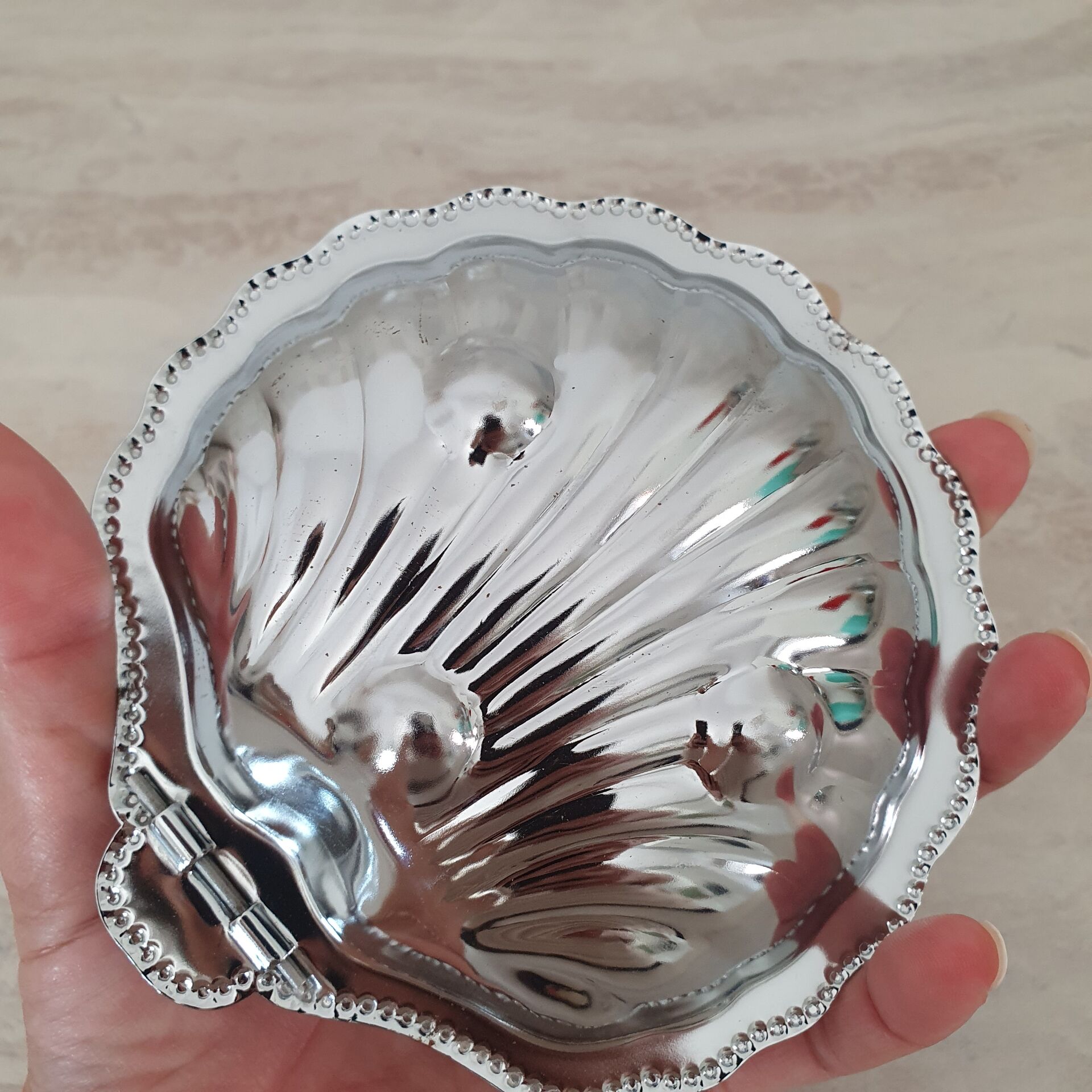 Shell-shaped butter dish in stainless steel and white glass bowl.