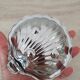 Shell-shaped butter dish in stainless steel and white glass bowl.