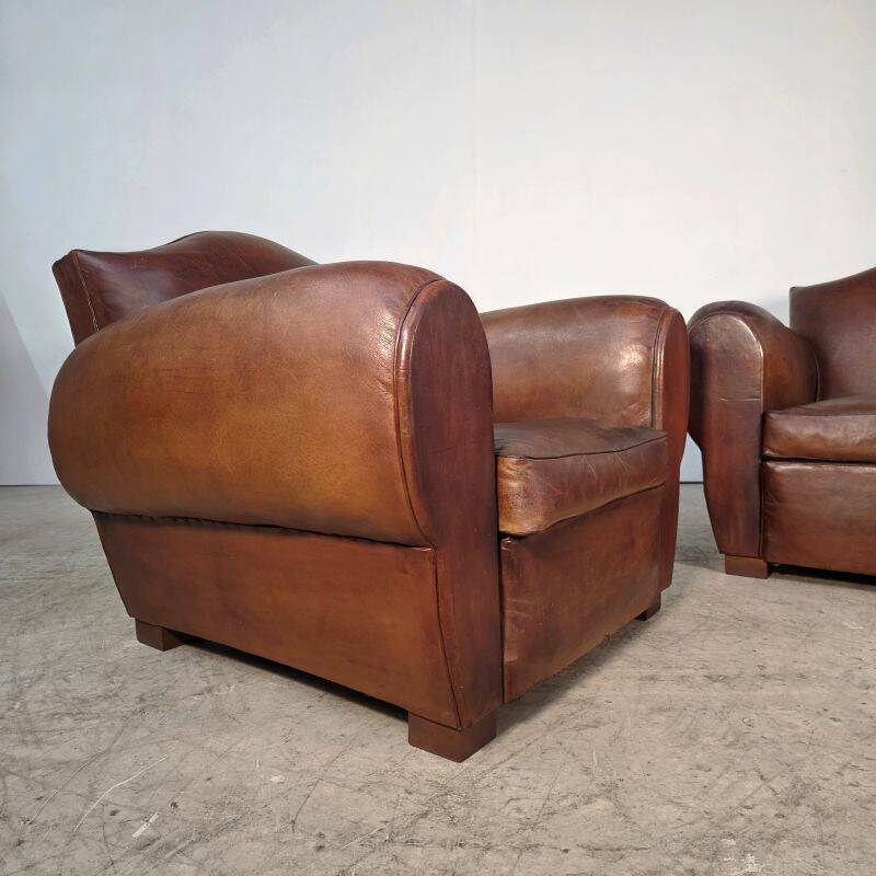 Important pair of Havana leather club armchairs, moustache models, mid-20th century.
