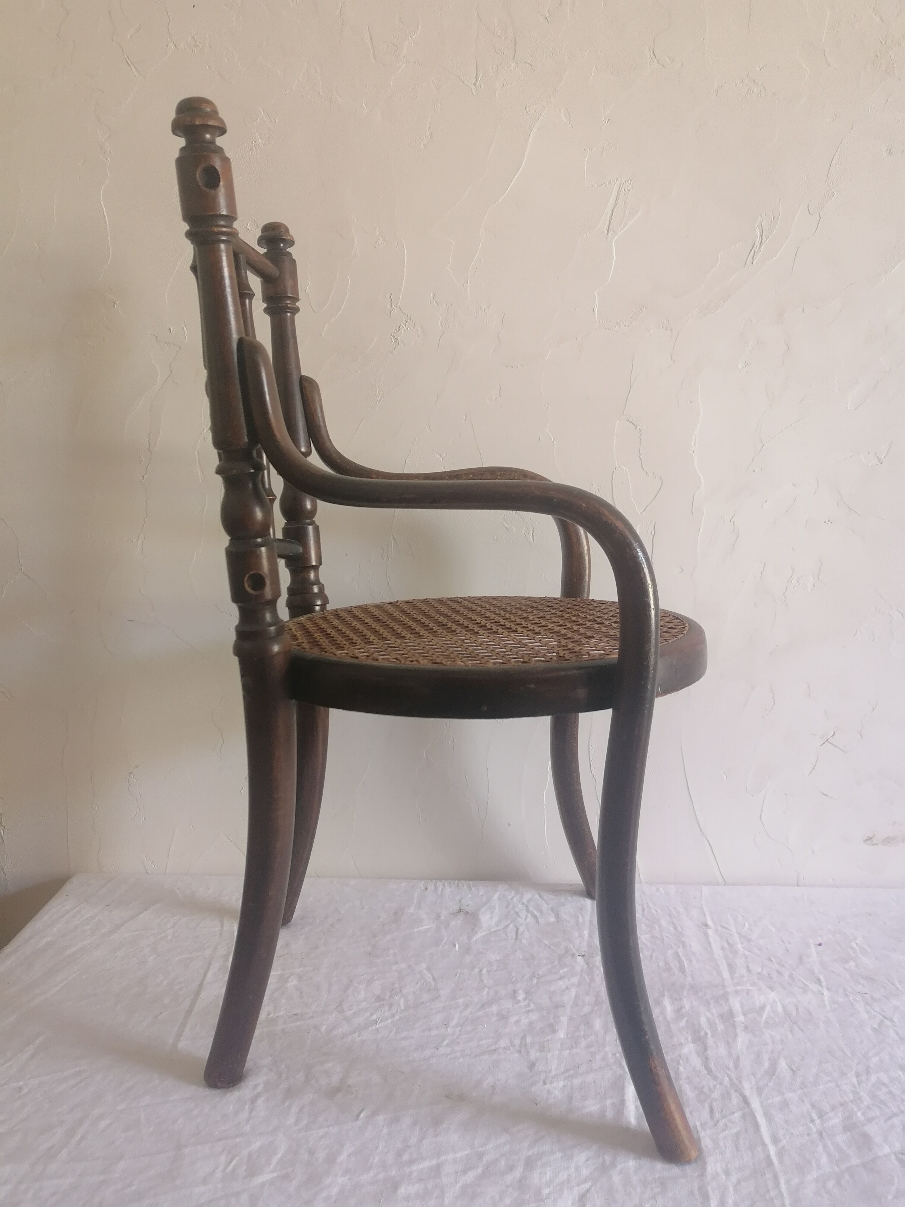 Old children's armchair in curved wood. Fischel