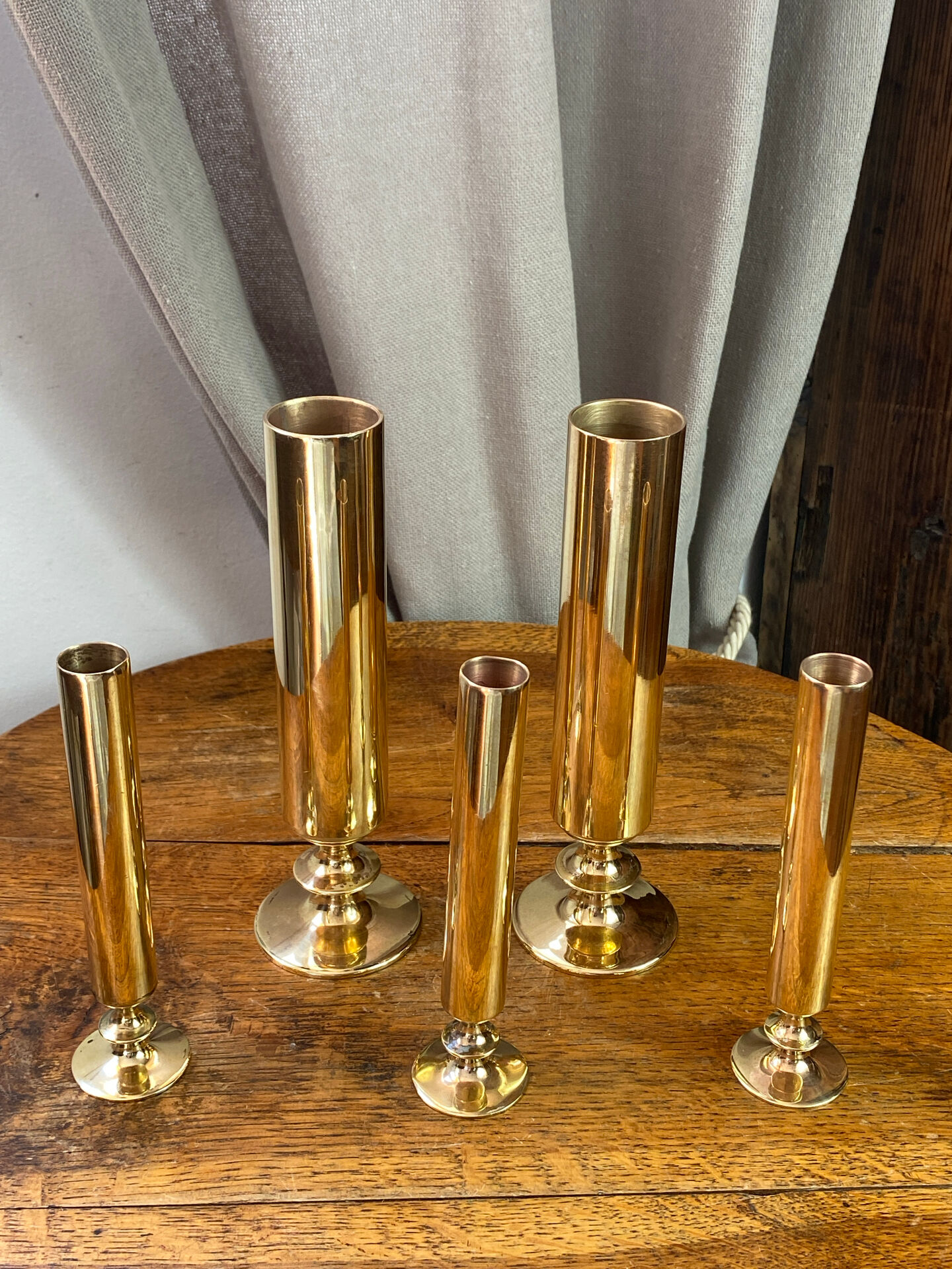 Set of candlesticks and tubular vases in solid brass.
