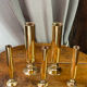 Set of candlesticks and tubular vases in solid brass.