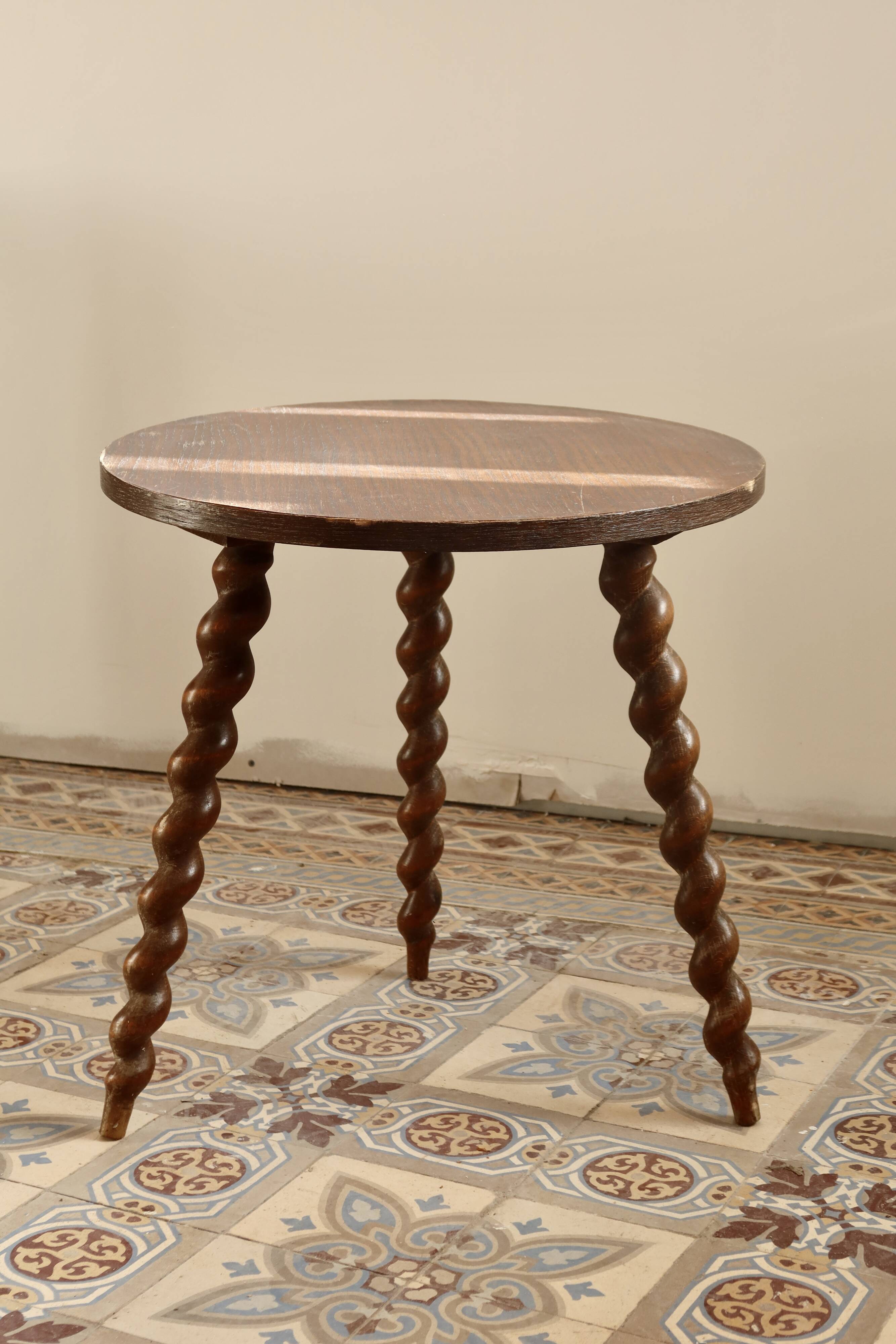 Vintage circular side table in wood with turned legs.