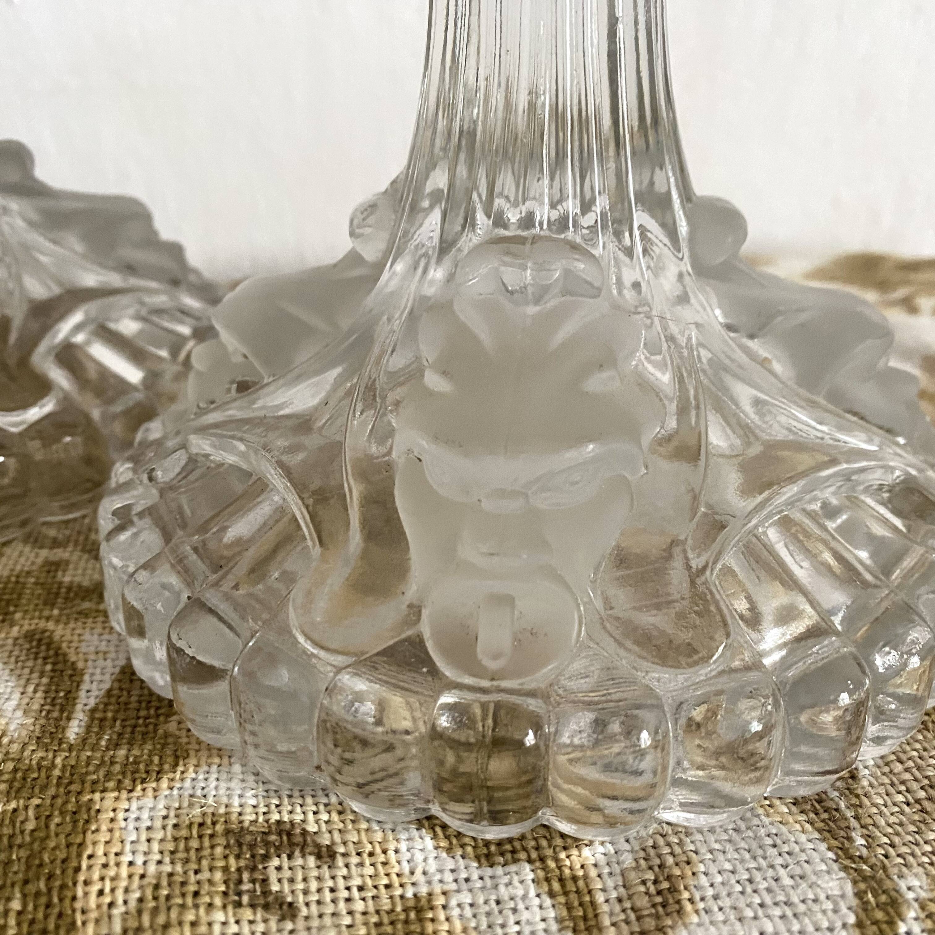 Pair of moulded glass candlesticks, ram heads and masks