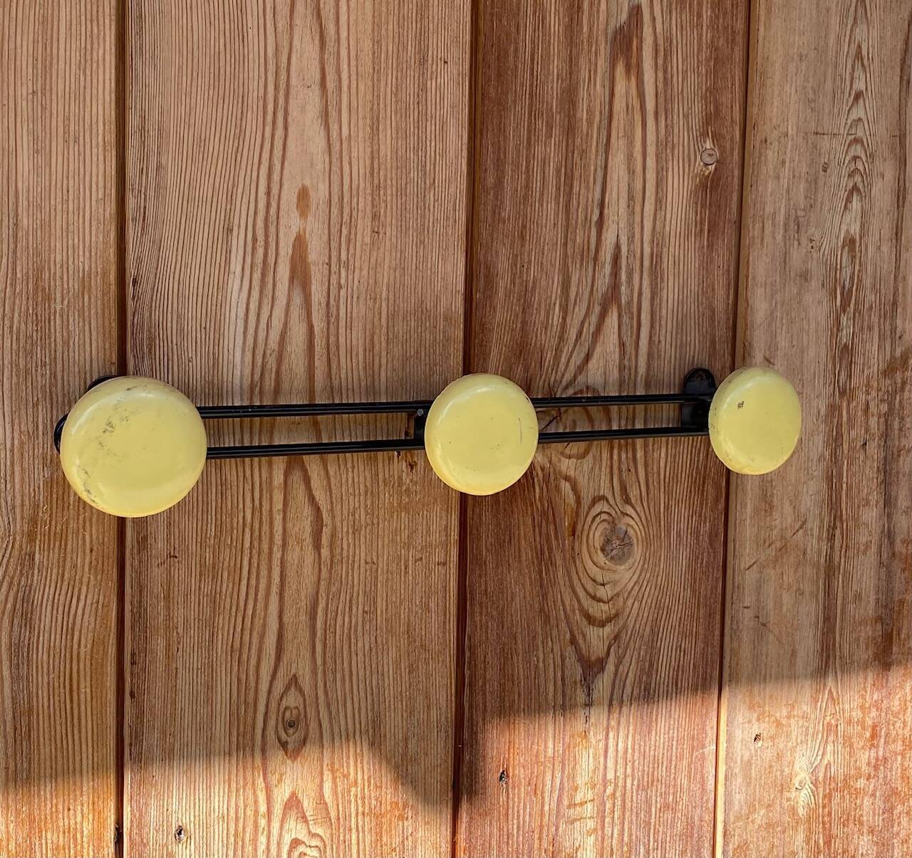 Vintage yellow metal wall coat rack