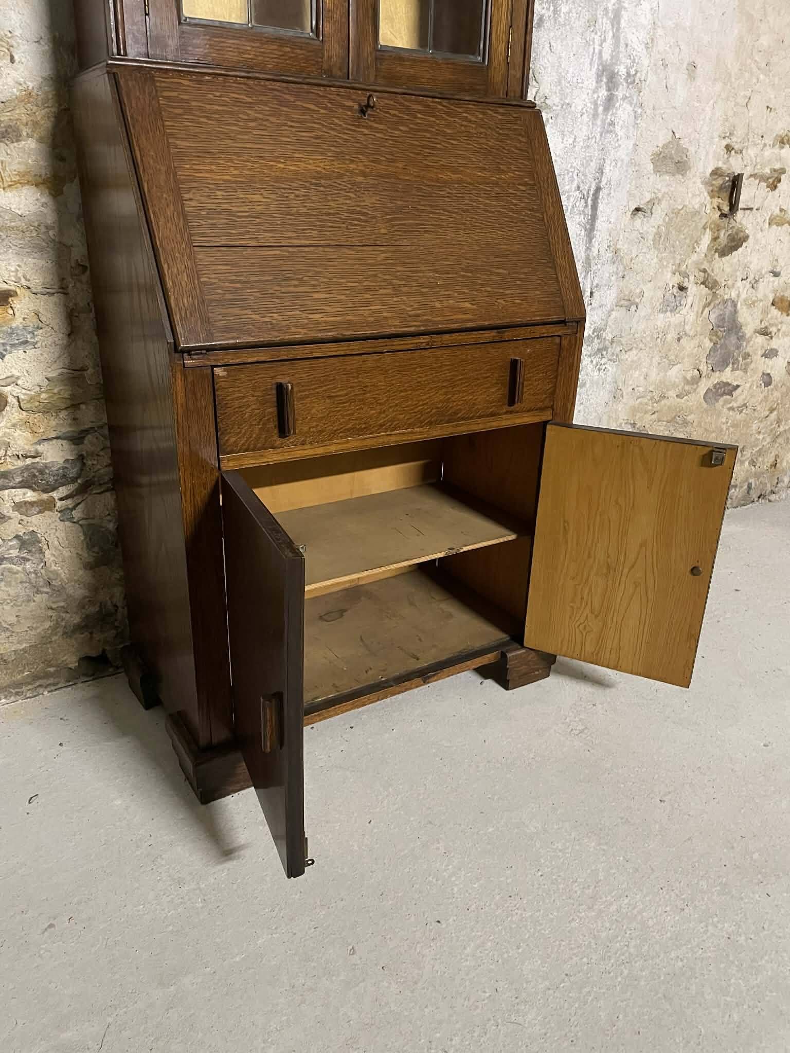 Oak display secretary cabinet with drop-down front, two sections.
