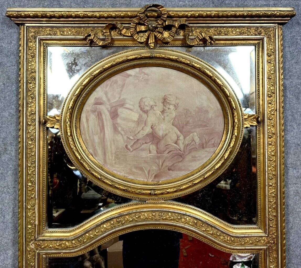 Very large mirror with mouldings, richly carved and gilded, in the Louis XVI style.