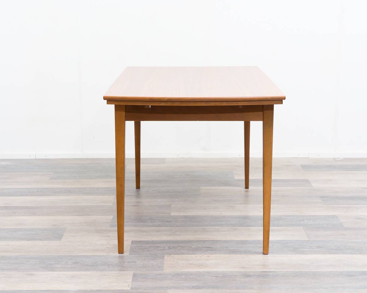 Dining table, 1960s, in walnut, slightly elliptical shape.