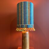 "Stoneware Bottle Lamp" with a multicoloured blue lampshade handwoven in India.