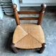 Low brutalist chair in dark wood and straw n°1