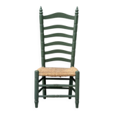 Vintage low accent chair with a high back and woven seat.