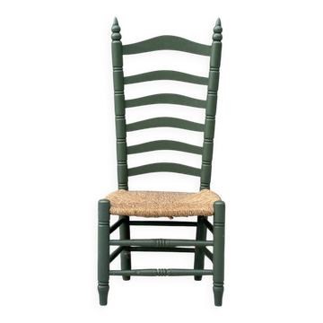 Vintage low accent chair with a high back and woven seat.