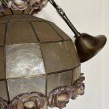Vintage pendant light with a pearlescent shade and floral decoration.