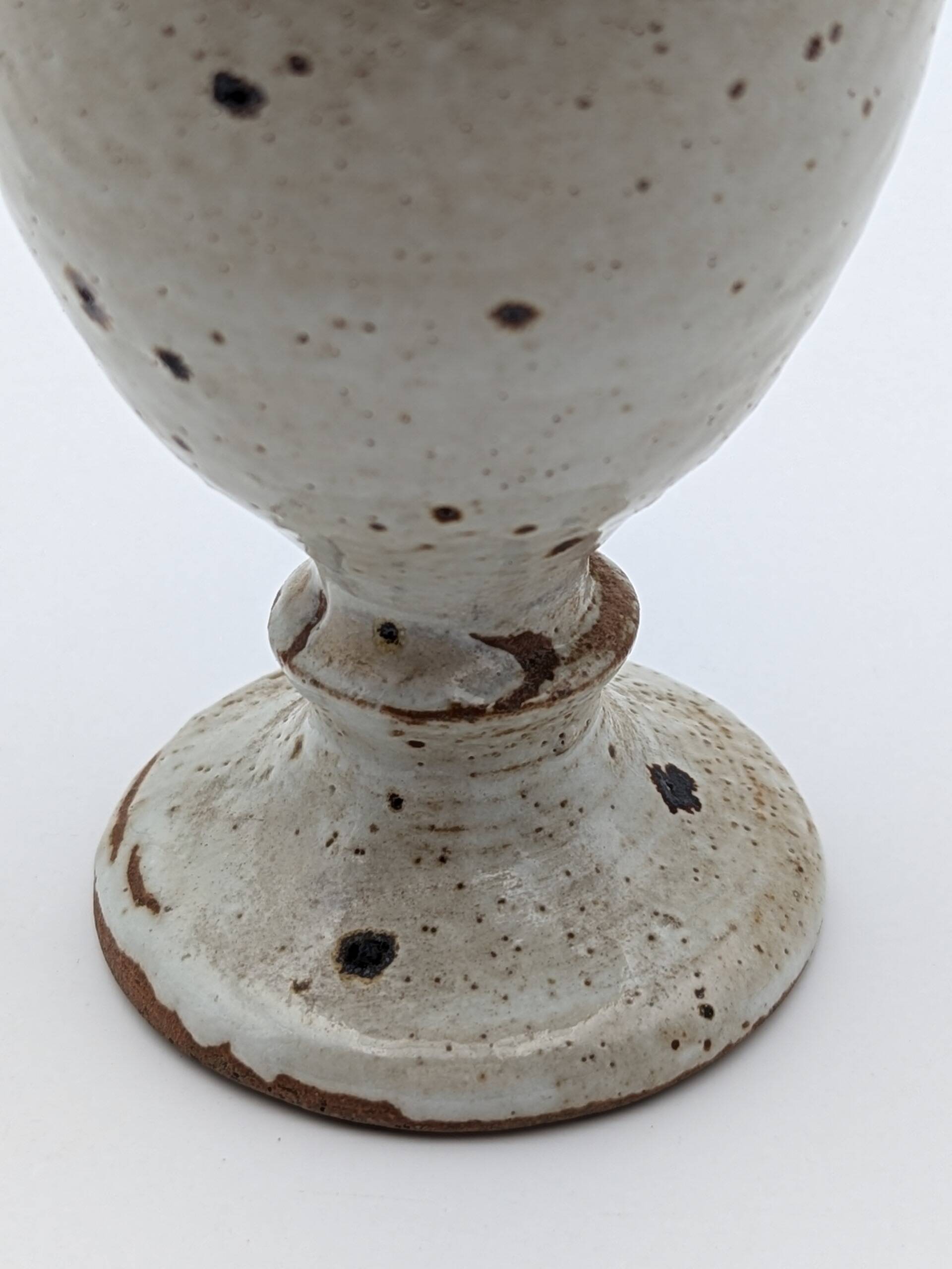 Glass on foot in pearly white stoneware with black spots