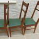 6 modern chairs with banded backs and green faux leather seats.