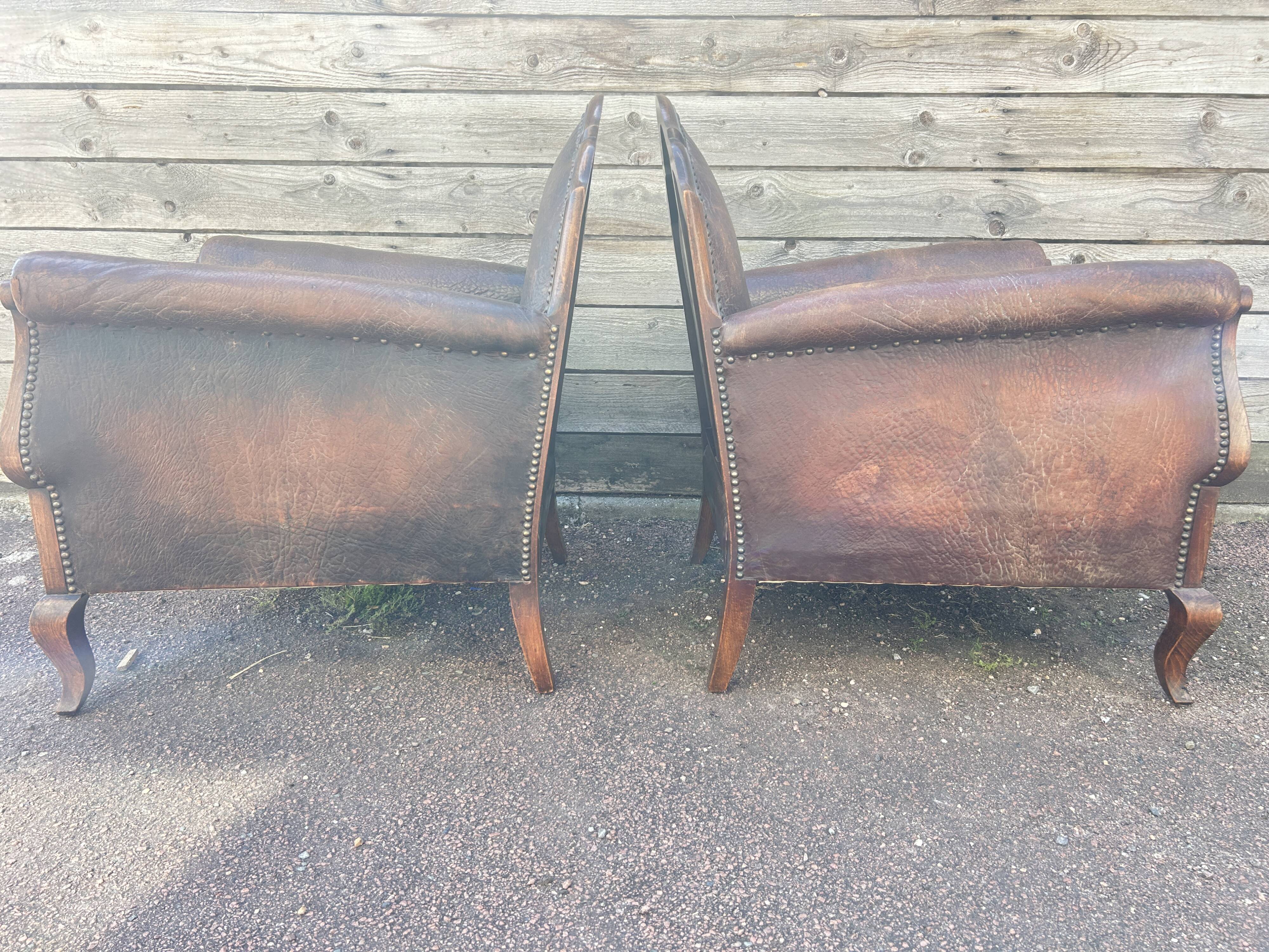 Pair of club armchairs in wood and leather, early 20th century.