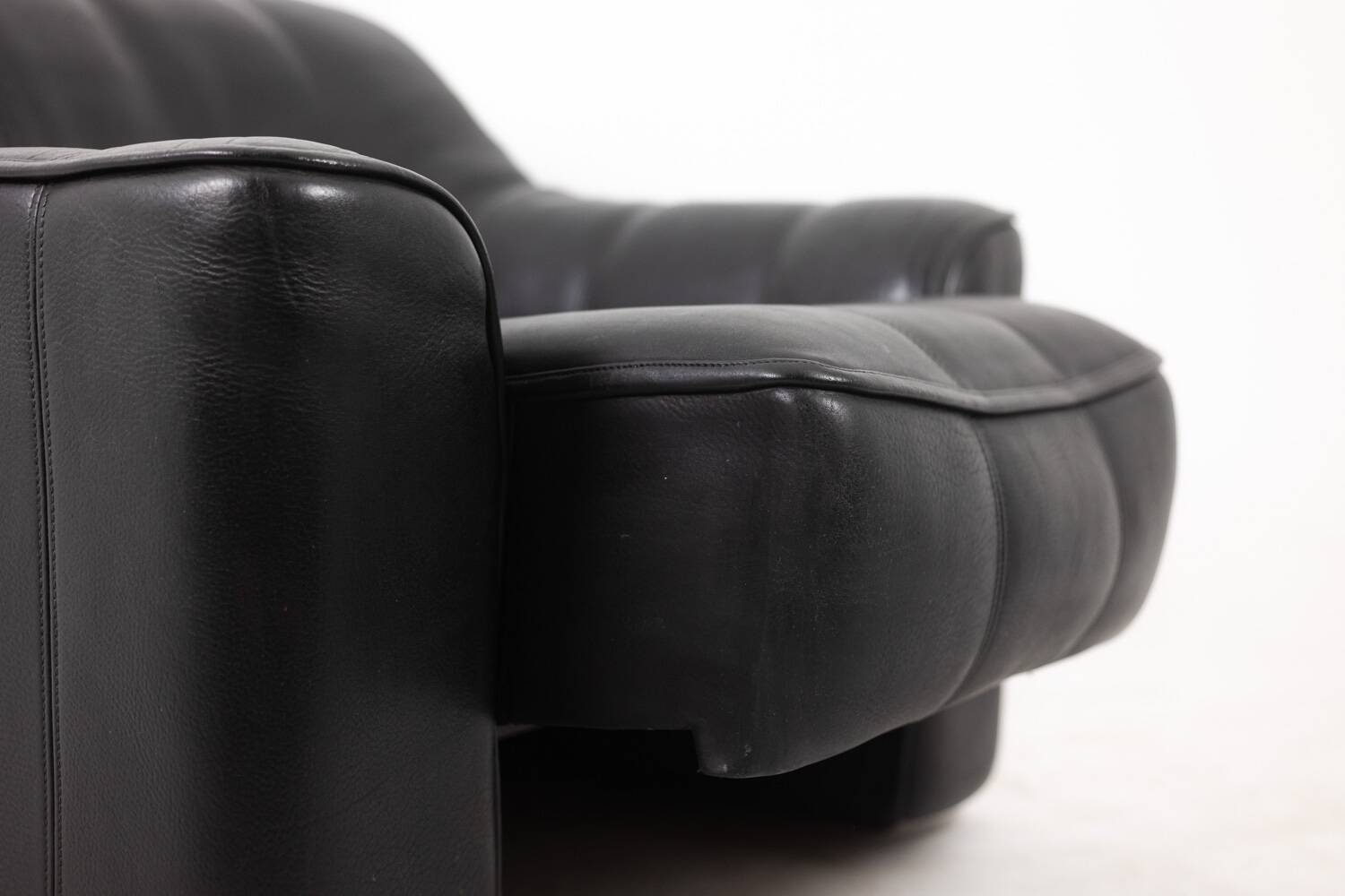 Maison De Sede. Armchair and its ottoman in black leather. 1970s.