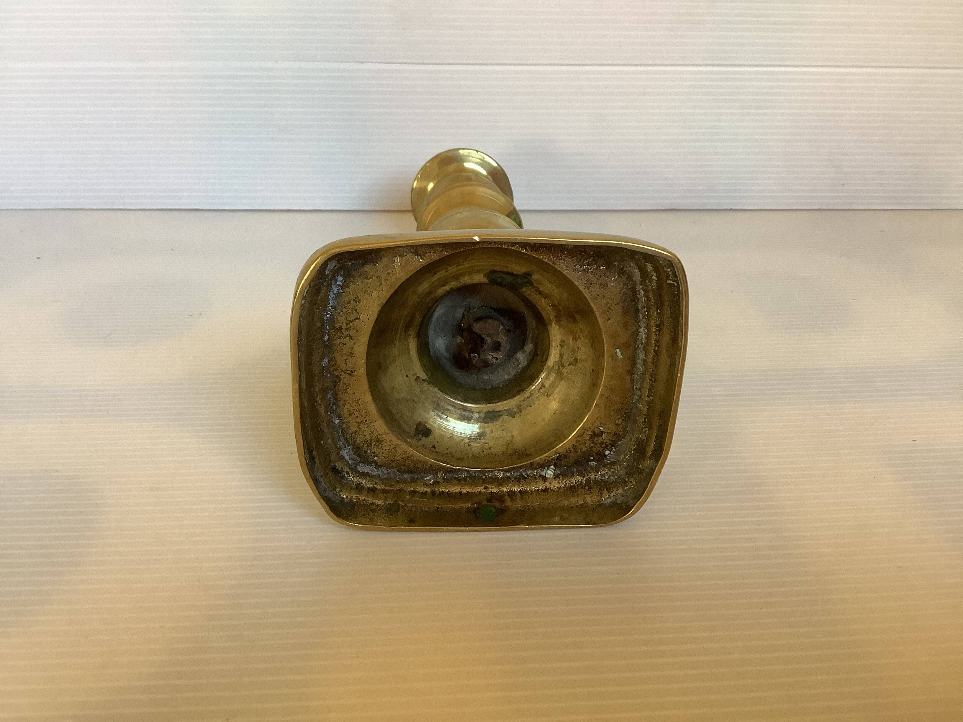 Brass candlestick with a rectangular base.