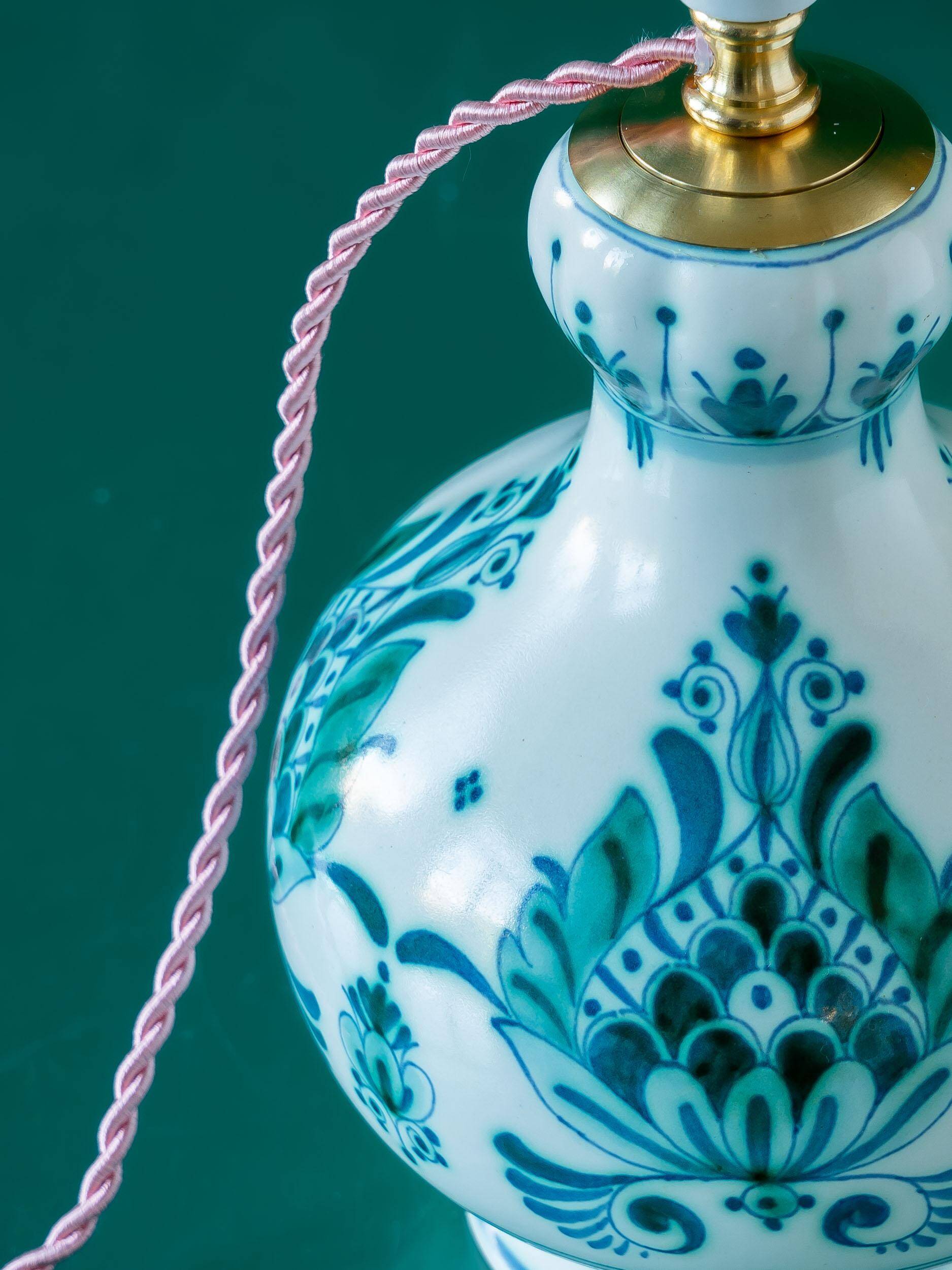 Royal Delft blue-green ceramic table lamp with pink jacquard peacock shade.