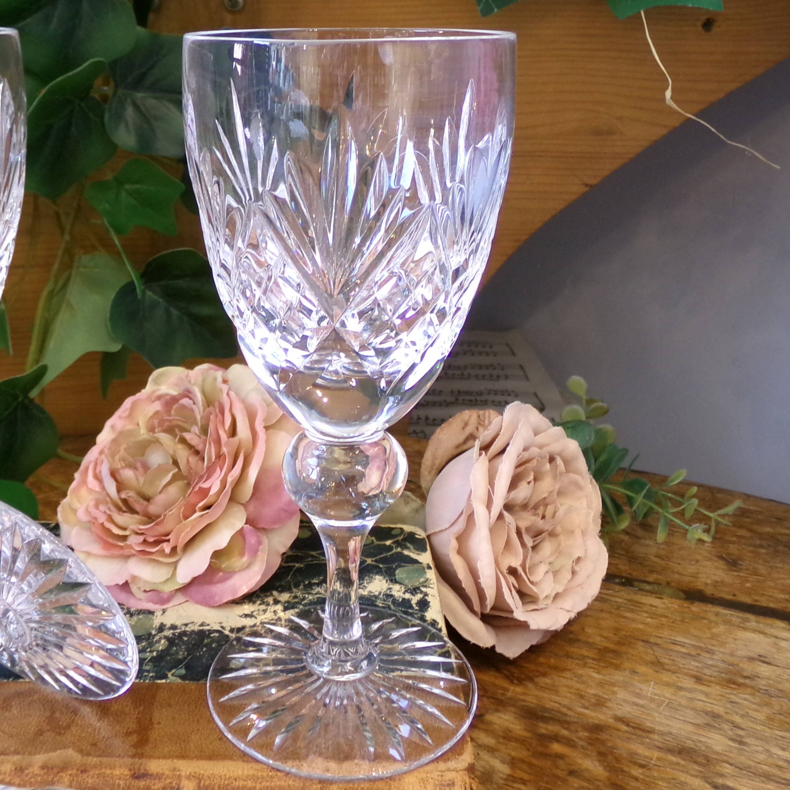 Cut crystal white wine glasses with a slender baluster-shaped stem.