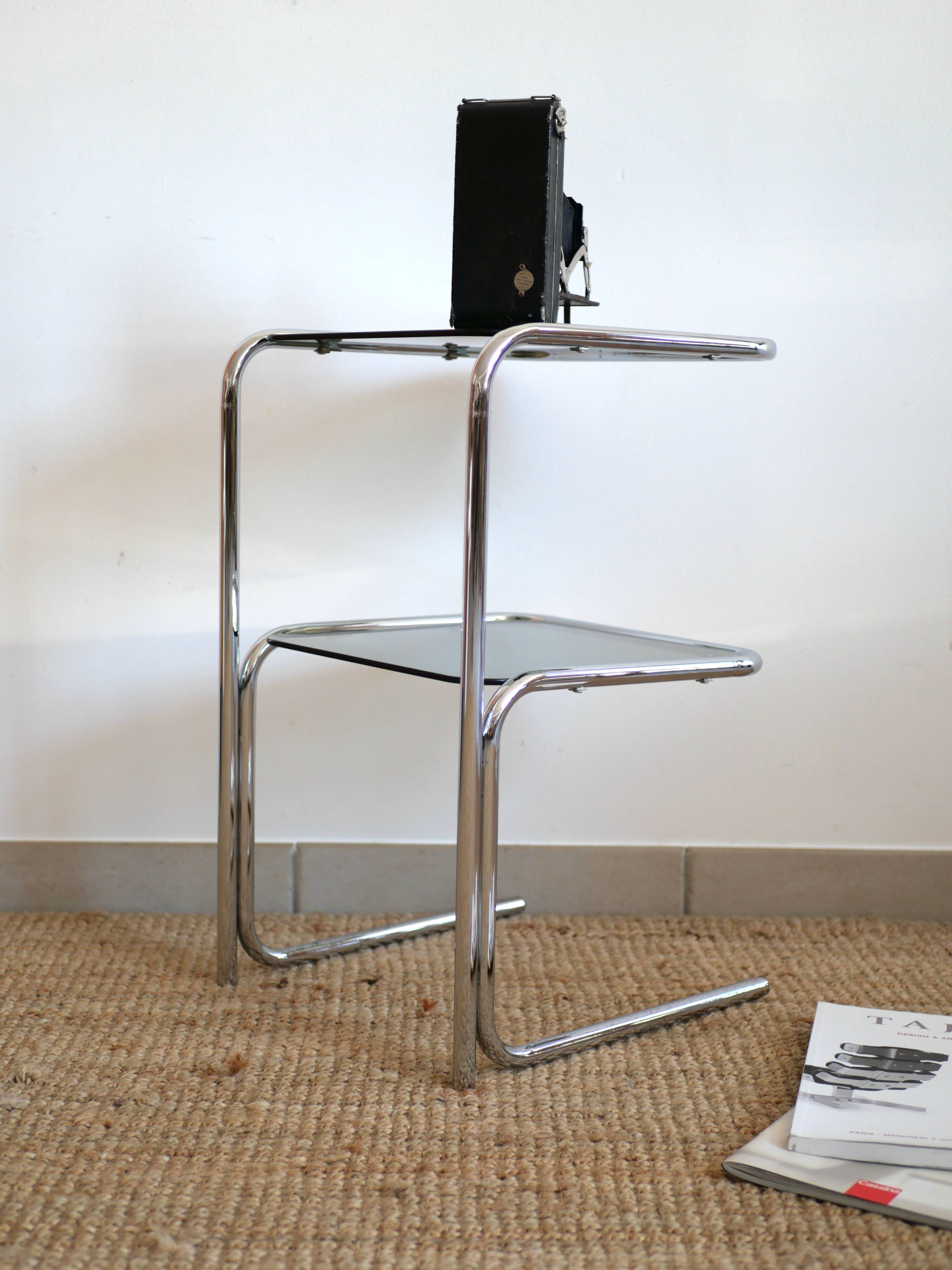 Glass-topped side table with tubular metal.