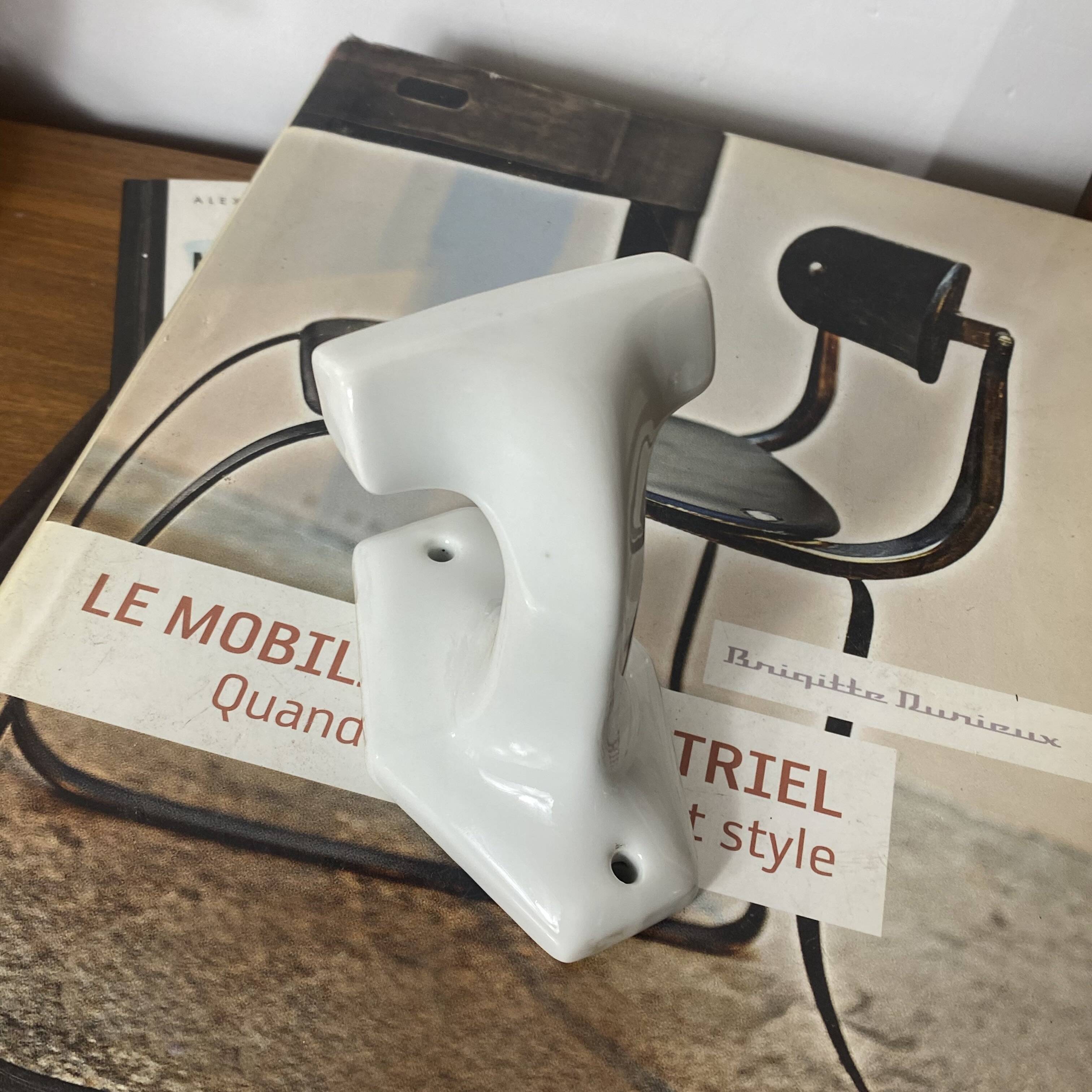 An antique white porcelain coat hook towel holder.
