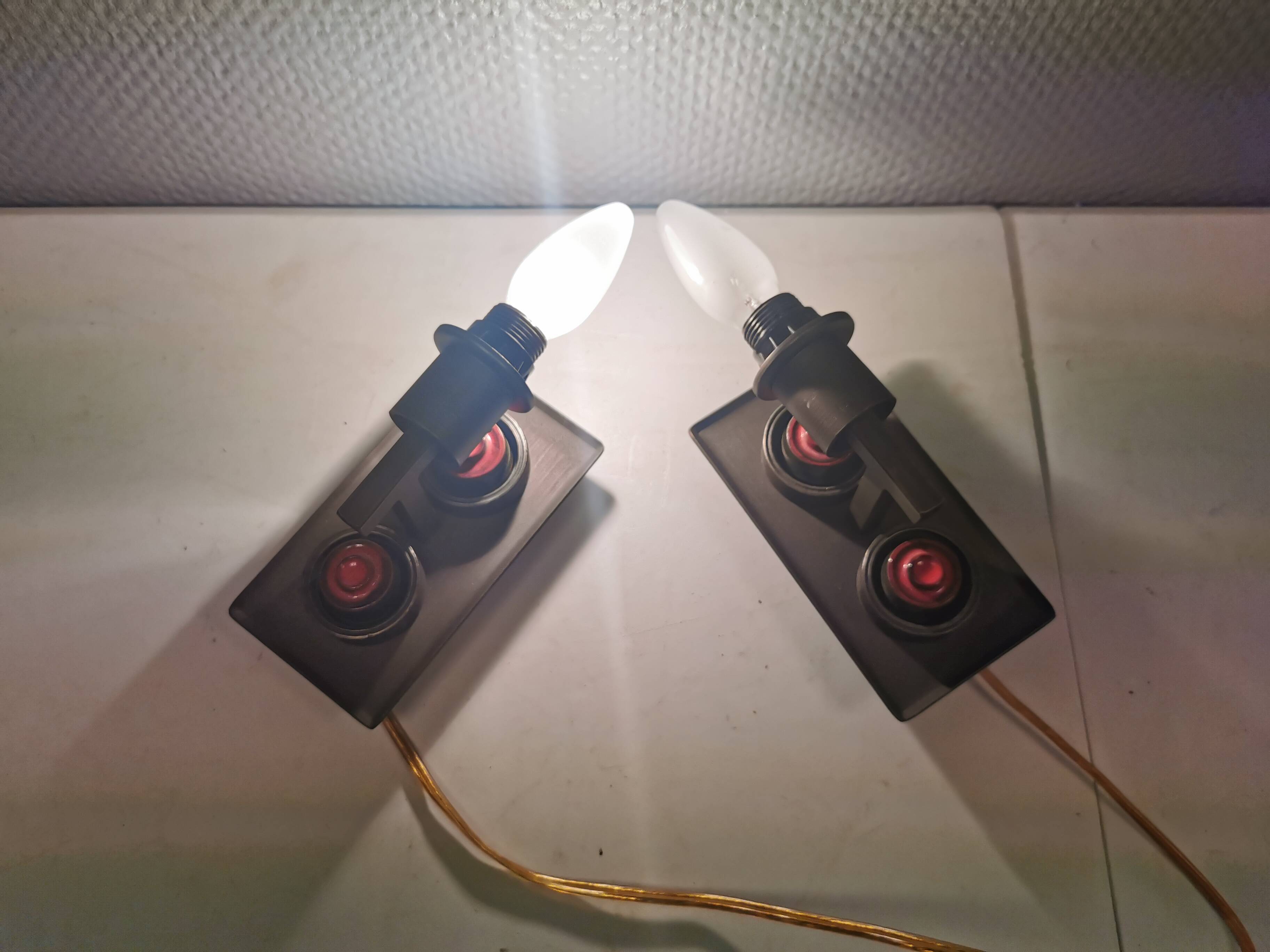 A set of Vitrika Denmark, cast iron wall lights with red details.