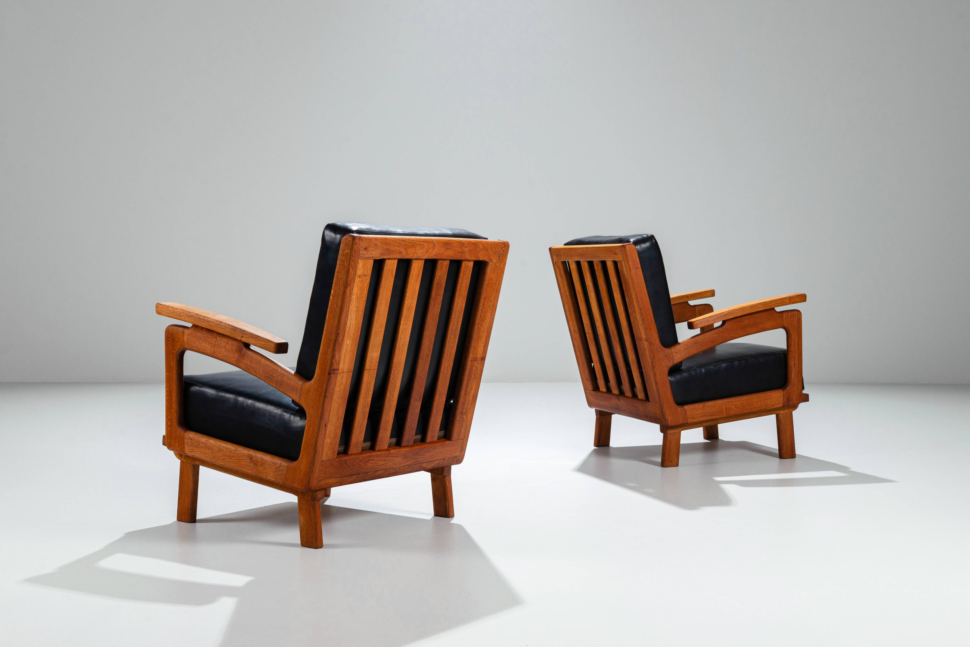 Pair of Belgian lounge chairs in solid oak with leather cushions